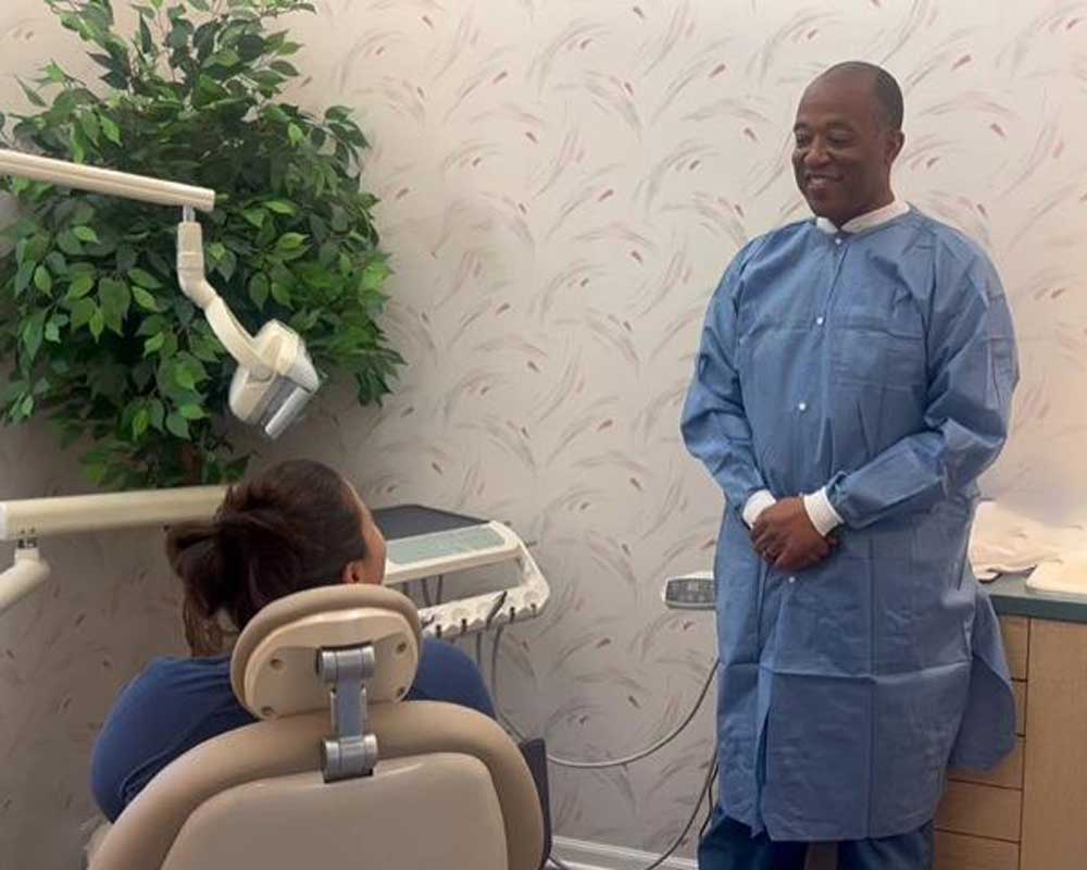Dentist in blue gown smiling at patient at Whittier Palm Dental in Montebello, CA
