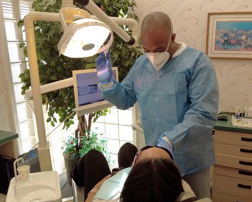 Dentist examining patient under light at Whittier Palm Dental in Montebello, CA